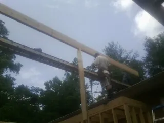 Carpenter setting a ridge beam over a new addition frame — Ice Dam Removal by Roofing Brothers in South Bloomingville