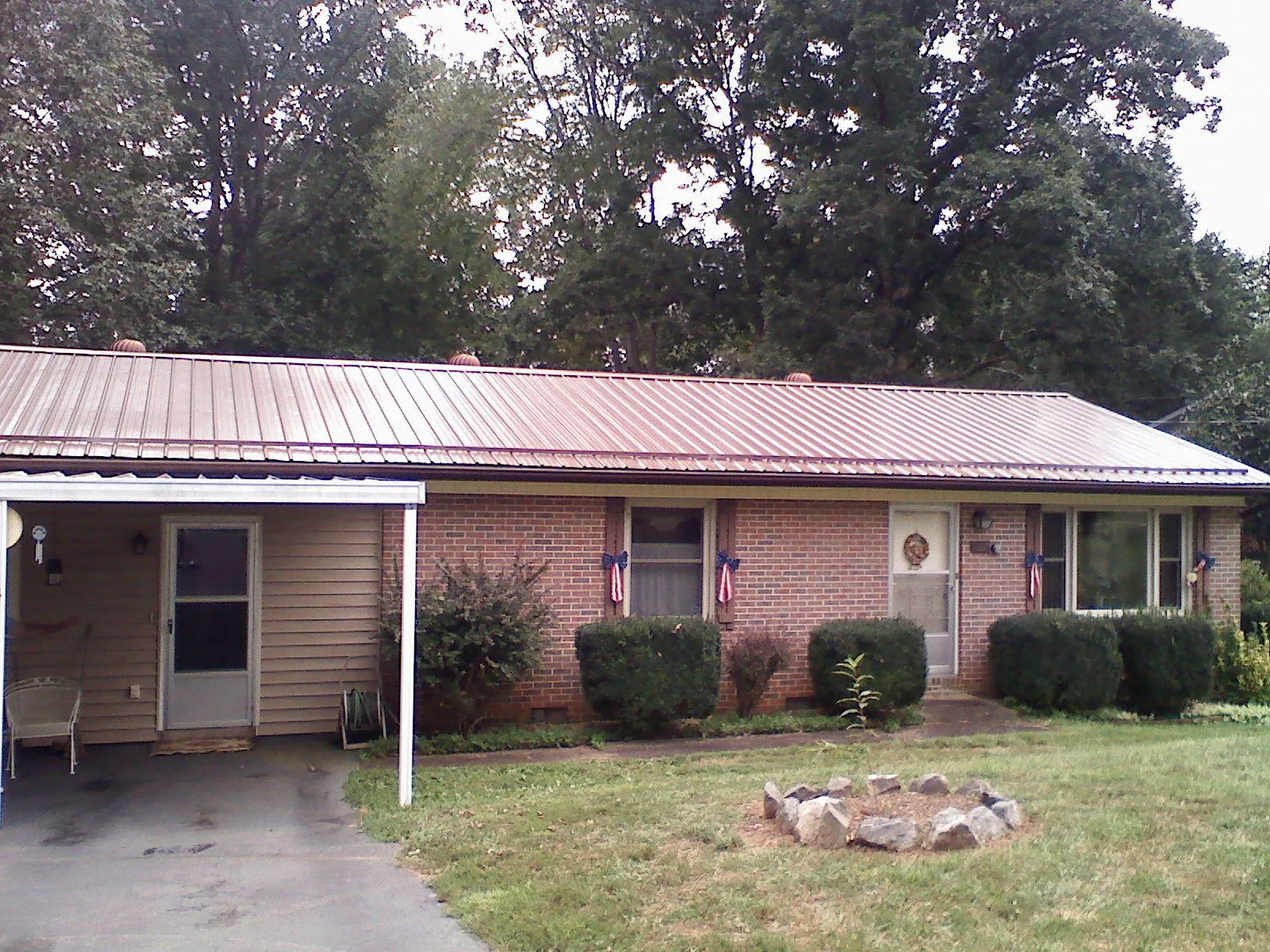 Bronze metal roof and carport on a brick ranch home — Roof Repair work by our crew in South Bloomingville